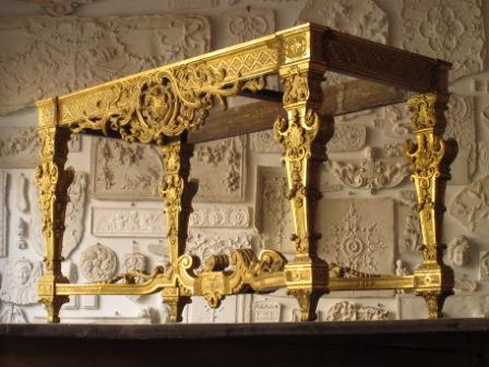 Table dorée à la feuille devant la plâtrothèque